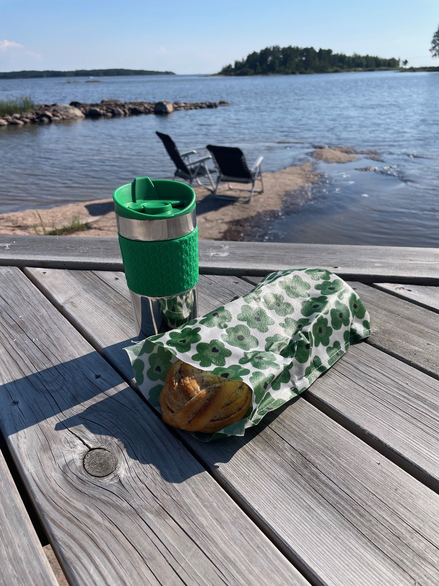 Ekeby bivaxpåse med bullar i, som ligger på en brygga med sjö bakom