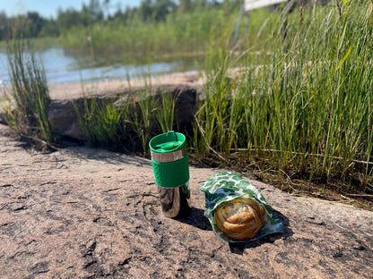 Ekeby bivaxpåse med bullar och kaffetermos på klippa med sjö bakom